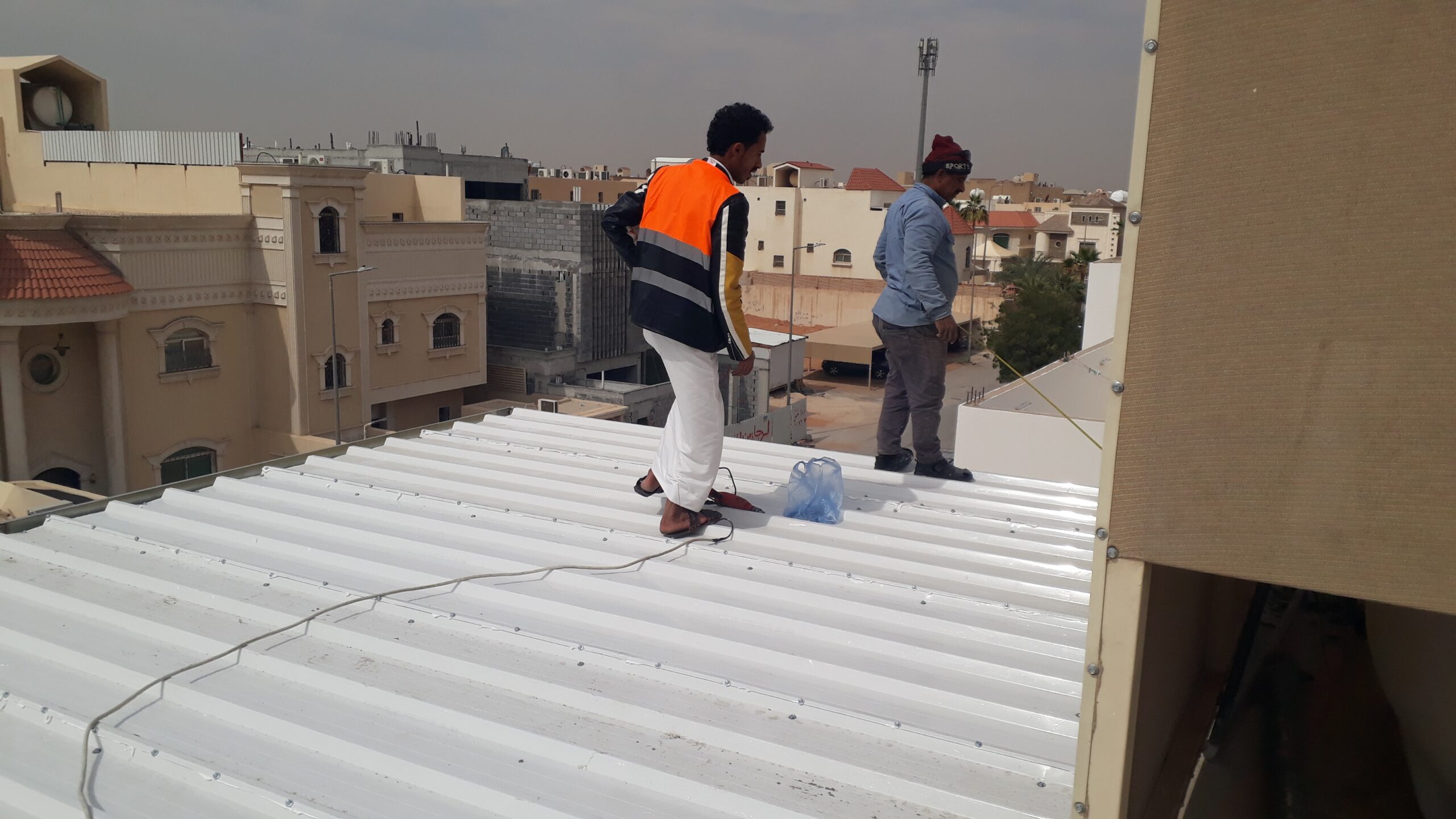 فنيين يركبون ألواح الساندوتش بانل باستخدام أدوات حديثة